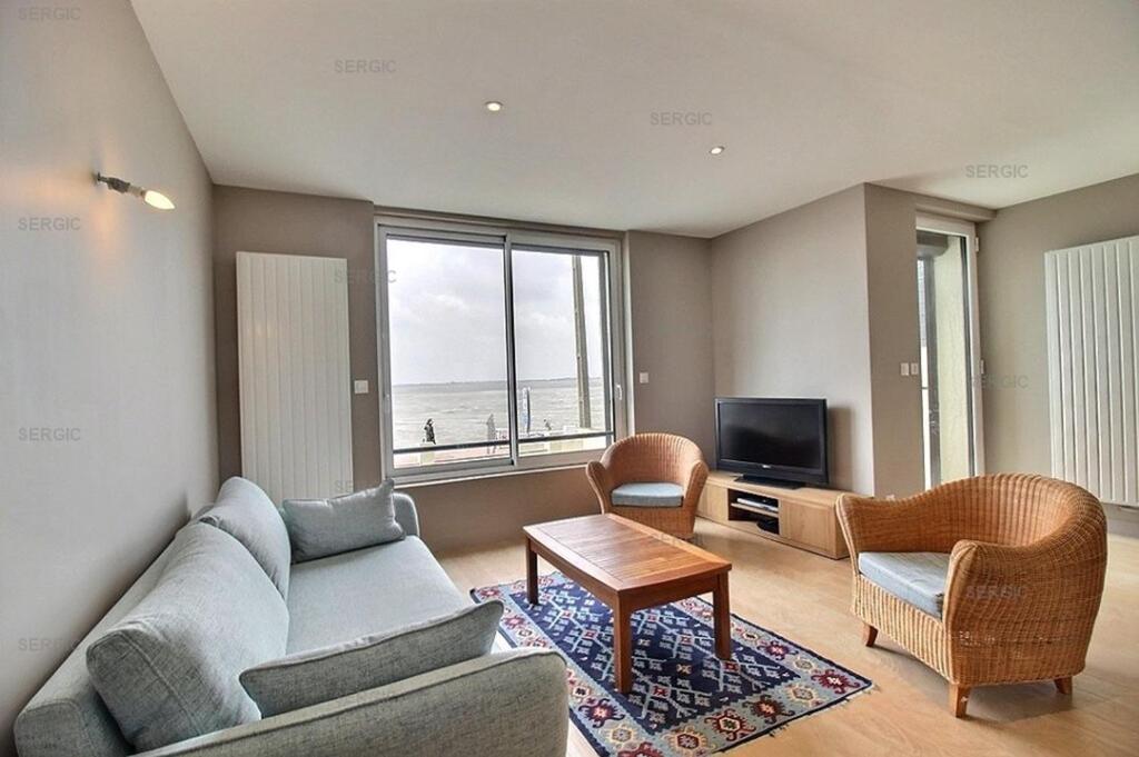 un salon avec un canapé, des chaises et une télévision dans l'établissement BELLEVUE Belle maison en front de mer, au Crotoy