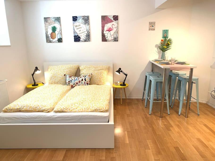 - une chambre avec un lit et une table avec des tabourets dans l'établissement Gemütliches Nest mitten in STUTTGART, à Stuttgart