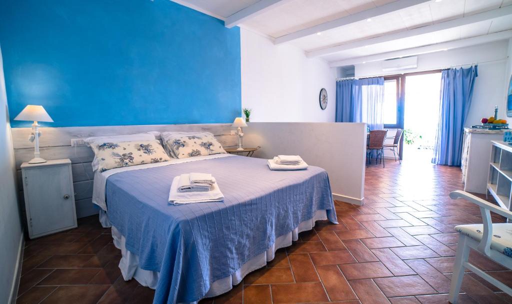 タオルミーナにあるStivaの青いベッドルーム(タオル付きのベッド付)