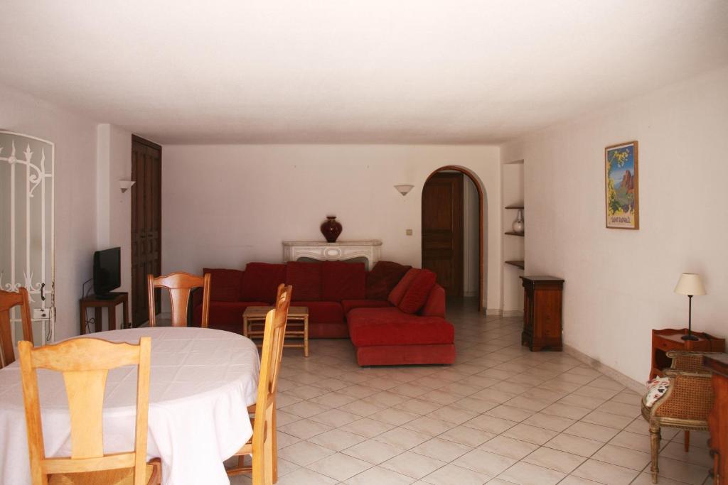 un salon avec un canapé rouge et une table dans l'établissement Charmant F5 à Saint Raphaël, à Saint-Raphaël