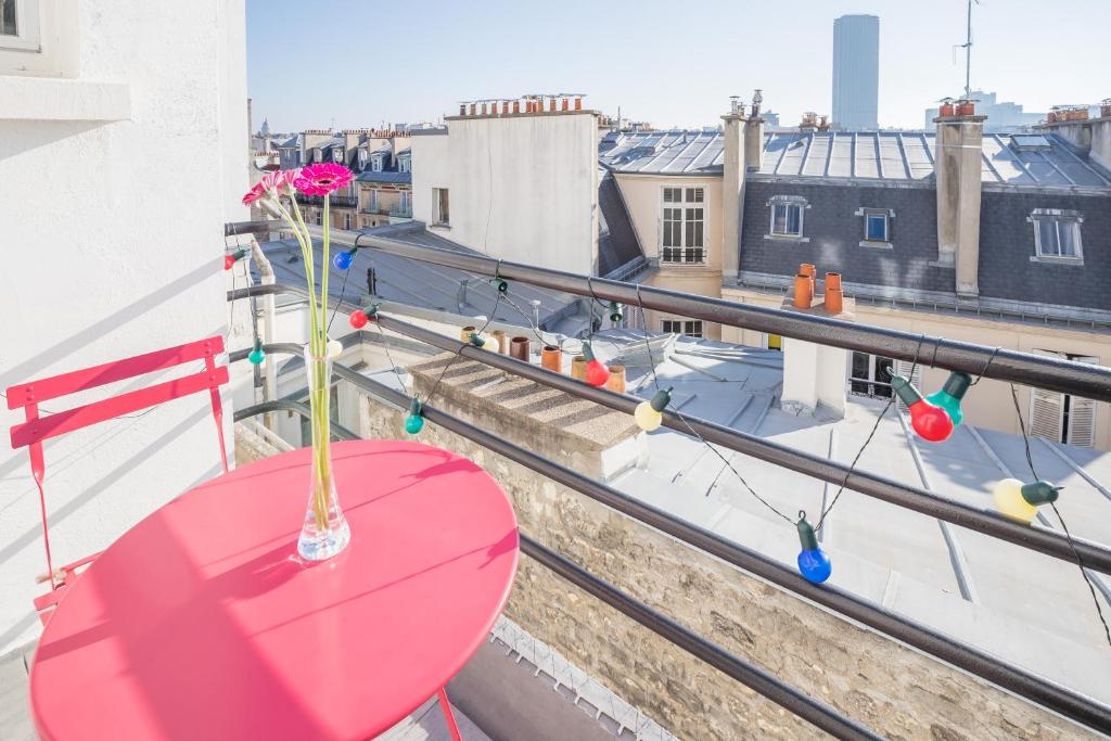 einen Balkon mit einem roten Tisch und Stadtblick in der Unterkunft Eiffel tower view and terrace in Paris
