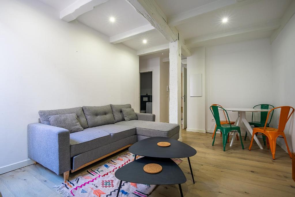 un salon avec un canapé et deux tables dans l'établissement Appartement T2 - Castellane/Cours Julien (climatisation et terasse), à Marseille
