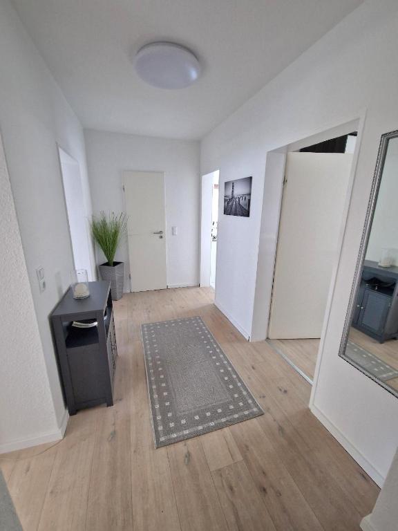 an empty living room with a rug and a mirror at Ferienwohnung Karlson in Wilhelmshaven
