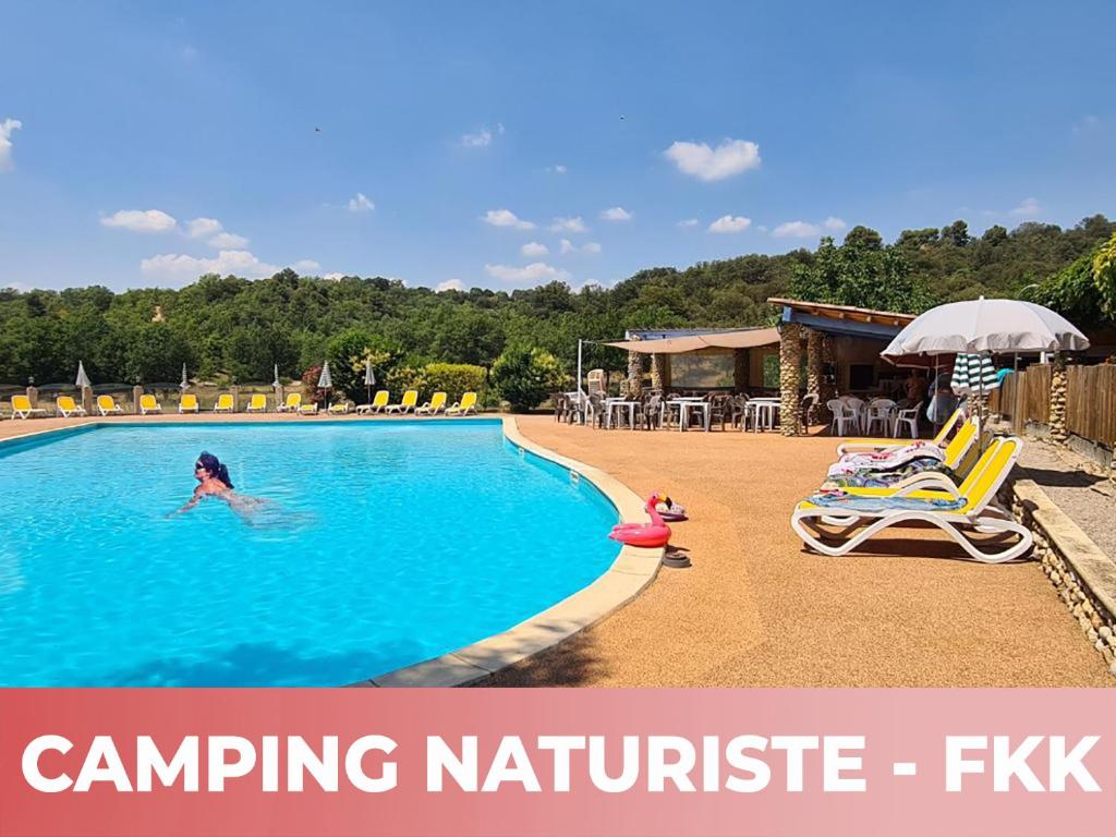 une femme nage dans une piscine dans l'établissement Camping Naturiste Tikayan Petit Arlane, à Valensole