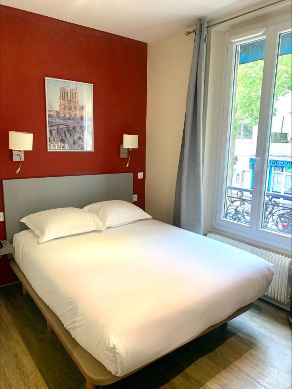 une chambre avec un grand lit blanc et une fenêtre dans l'établissement Hipotel Paris Belgrand Mairie du 20ème, à Paris