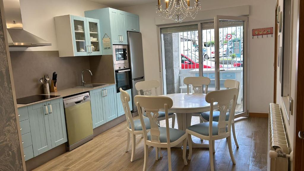 een keuken en eetkamer met een tafel en stoelen bij Apartamentos Torres del Milladoiro in Amés