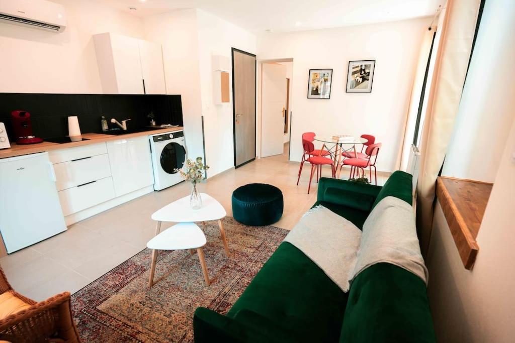 a living room with a green couch and a table at Appart 5 Charmant 2 pièces avec parking in Aix-les-Bains