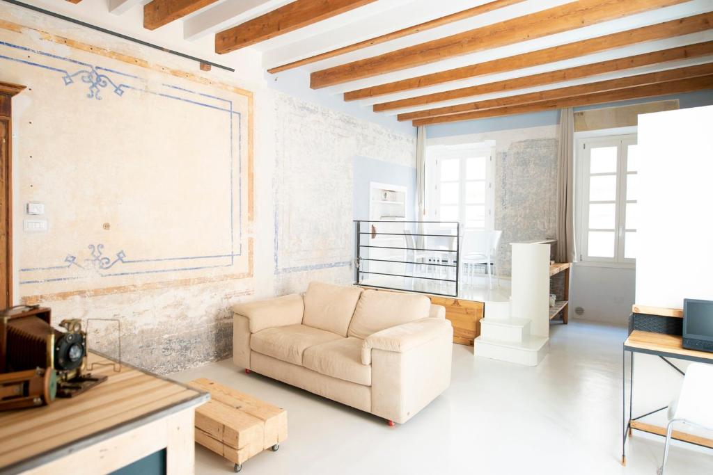 サッサリにあるHome Tola Raffinato appartamento in centroのソファとテーブルのあるリビングルーム