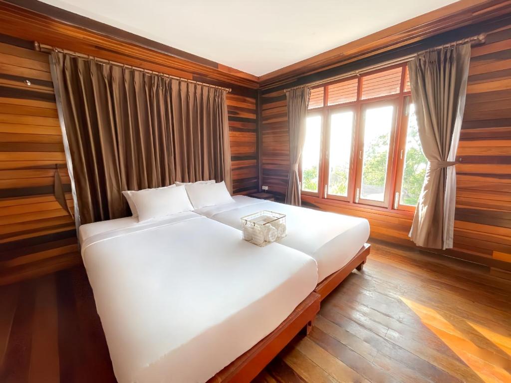 a white bed in a room with a window at Dusit Buncha Koh Tao by Riya Group in Ko Tao