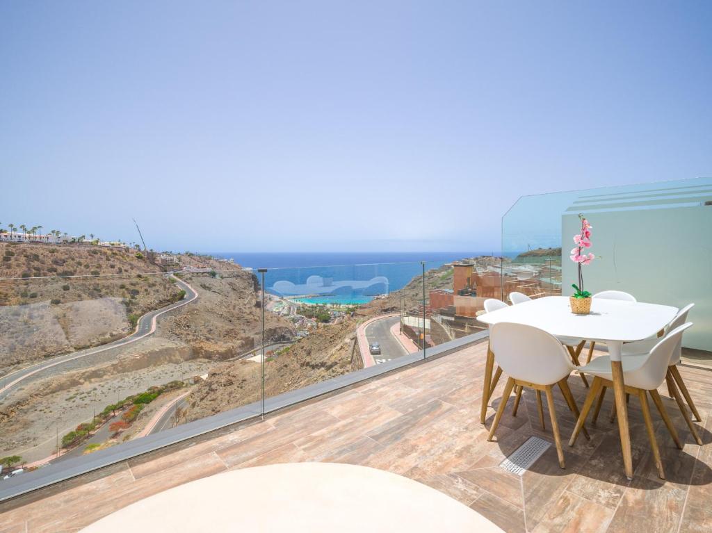 a balcony with a table and chairs and a view of the ocean at Beyond Amadores 11 in Mogán