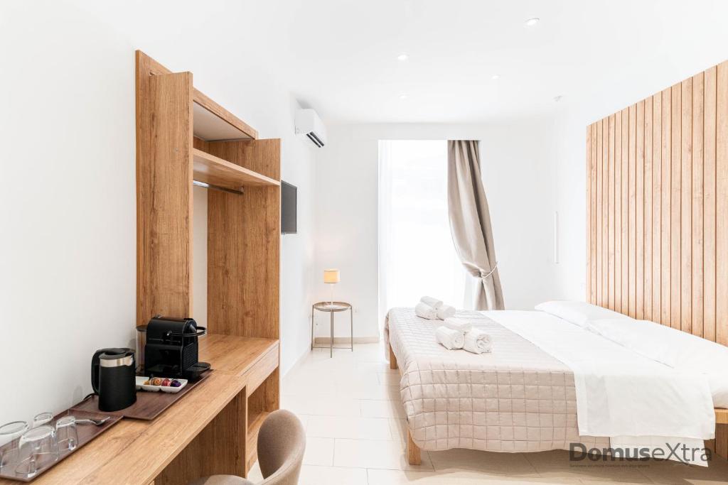 a bedroom with a bed and a table with a television at Olivia's Home By DomusExtra in Naples