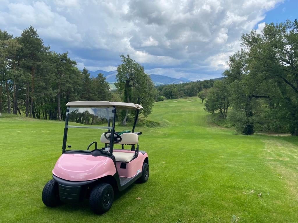 a pink golf cart parked on a lush green field at Golf Resort de Digne-les-Bains by Adonis in Digne-les-Bains