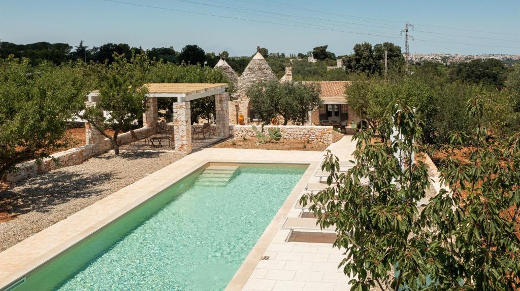 una piscina in un giardino con una casa di Trullo Felicità a Putignano