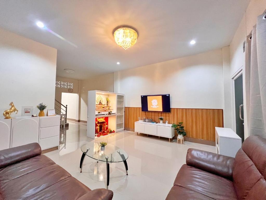 a living room with a couch and a tv at The Betong Life Guesthouse in Betong