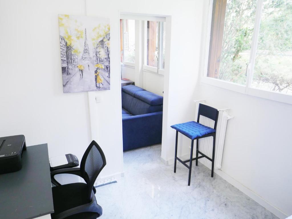 un salon avec une chaise bleue et une table dans l'établissement PARIS Tour EIFFEL, à Paris