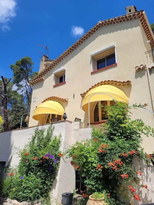 une grande maison avec des fleurs devant dans l'établissement Le Mas Les Salamandres, à Lorgues