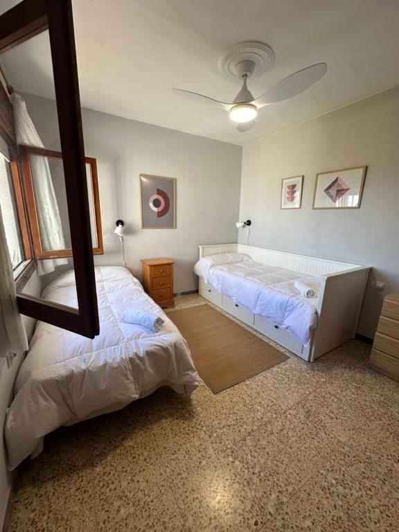 ein Schlafzimmer mit zwei Betten und einem Spiegel in der Unterkunft Bungalow Peñiscola REF 030 in Peñíscola