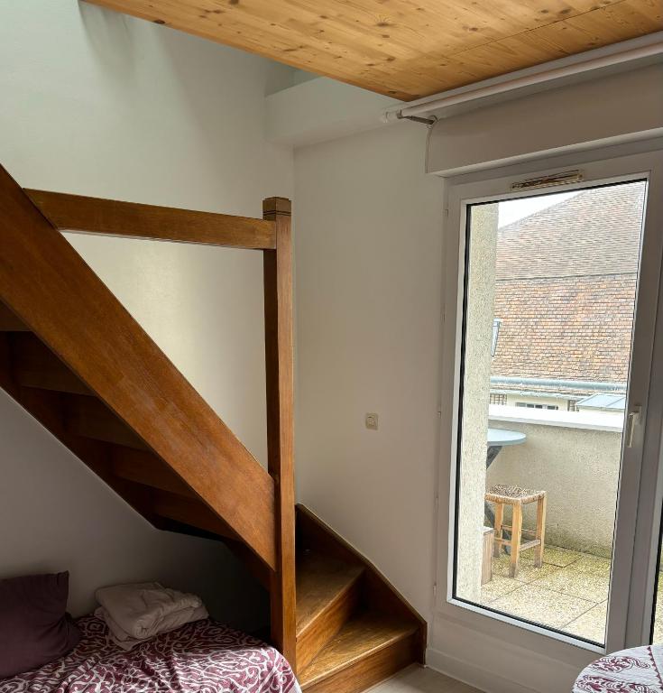 une petite chambre avec un escalier et une fenêtre dans l'établissement Studio chambre en mezzanine, à Meudon