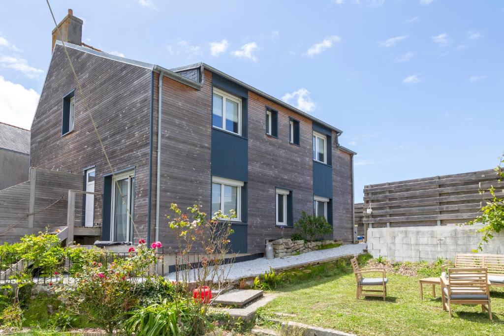 une maison en bois avec un jardin en face dans l'établissement Loft avec jardin 5min de la torche, à Plomeur