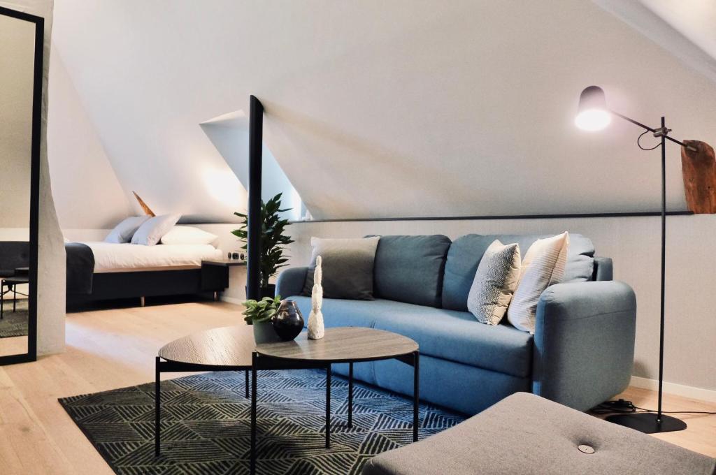 a living room with a blue couch and a table at Hotel-Restaurant Beim Schlass in Wiltz