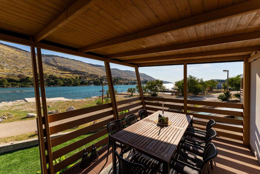 a table and chairs on a deck with a view of the water at Dream house by the sea in Grebaštica