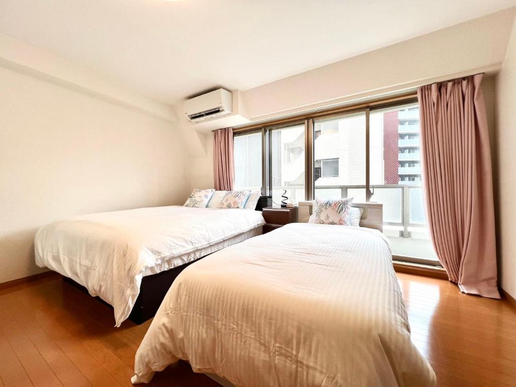two beds in a room with a window at Nishiwaseda 501 in Tokyo