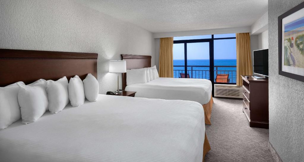 a hotel room with two beds and a balcony at Best Western Ocean Sands Beach Resort in Myrtle Beach