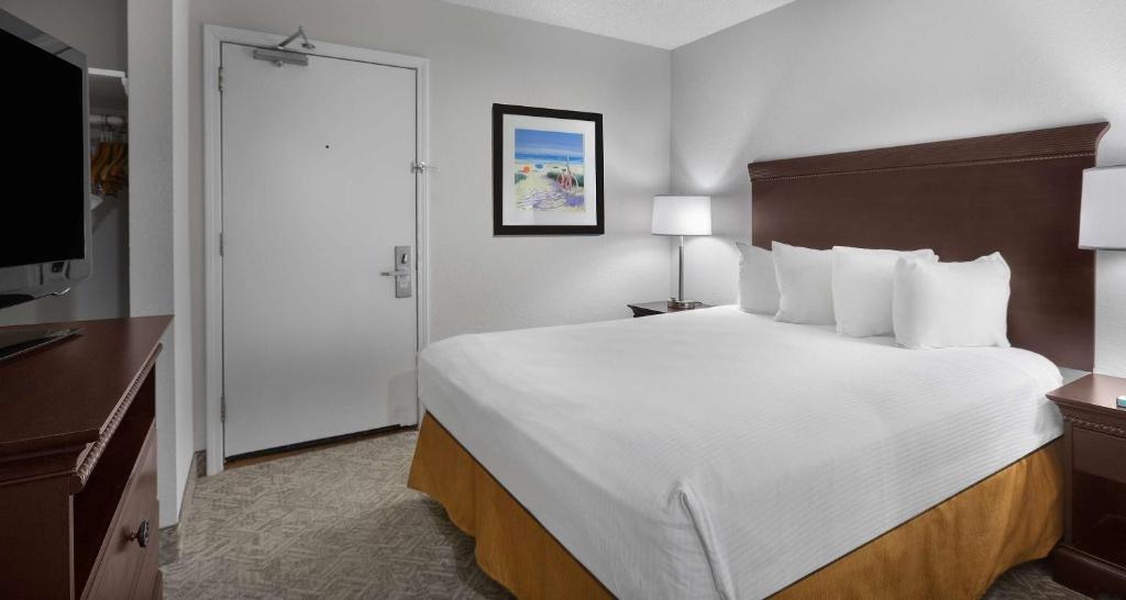 a hotel room with a large bed and a television at Best Western Ocean Sands Beach Resort in Myrtle Beach