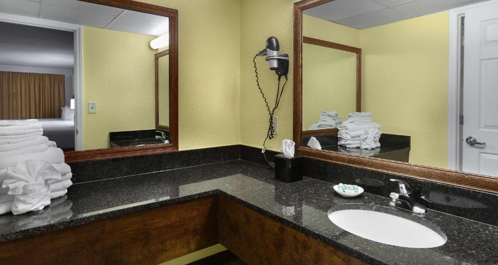a bathroom with a sink and a large mirror at Best Western Ocean Sands Beach Resort in Myrtle Beach