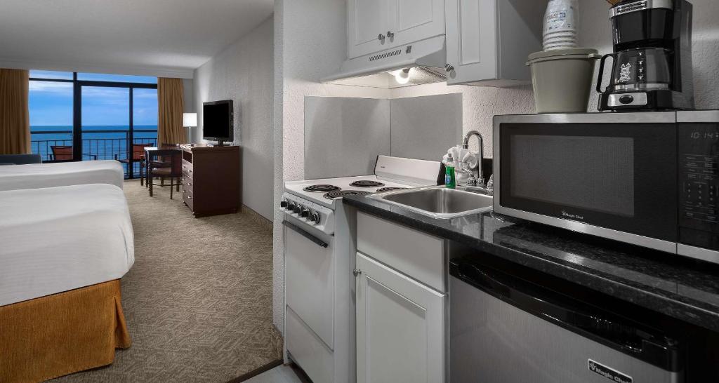 a kitchen with a sink and a microwave at Best Western Ocean Sands Beach Resort in Myrtle Beach