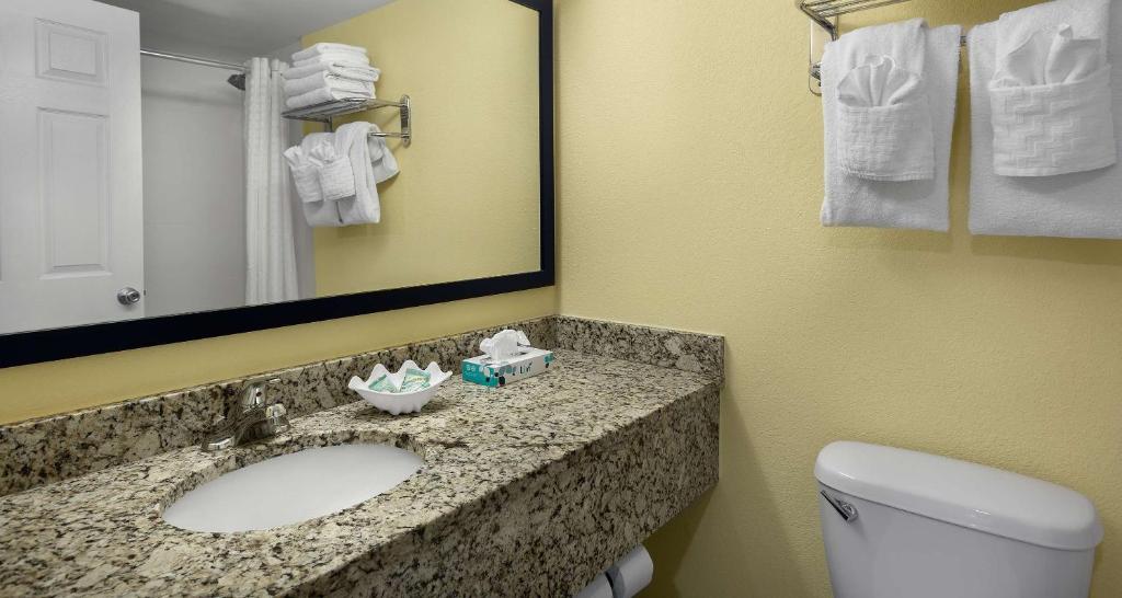 a bathroom with a sink and a toilet and a mirror at Best Western Ocean Sands Beach Resort in Myrtle Beach