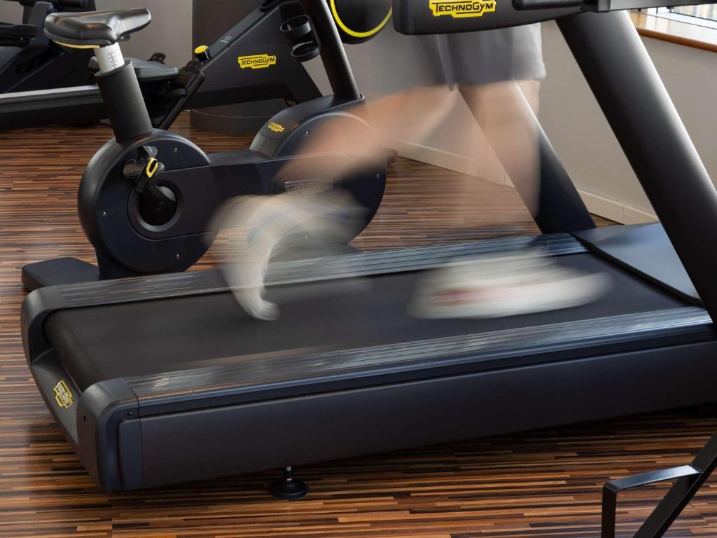 a person running on a treadmill in a gym at Sofitel Luxembourg Europe in Luxembourg