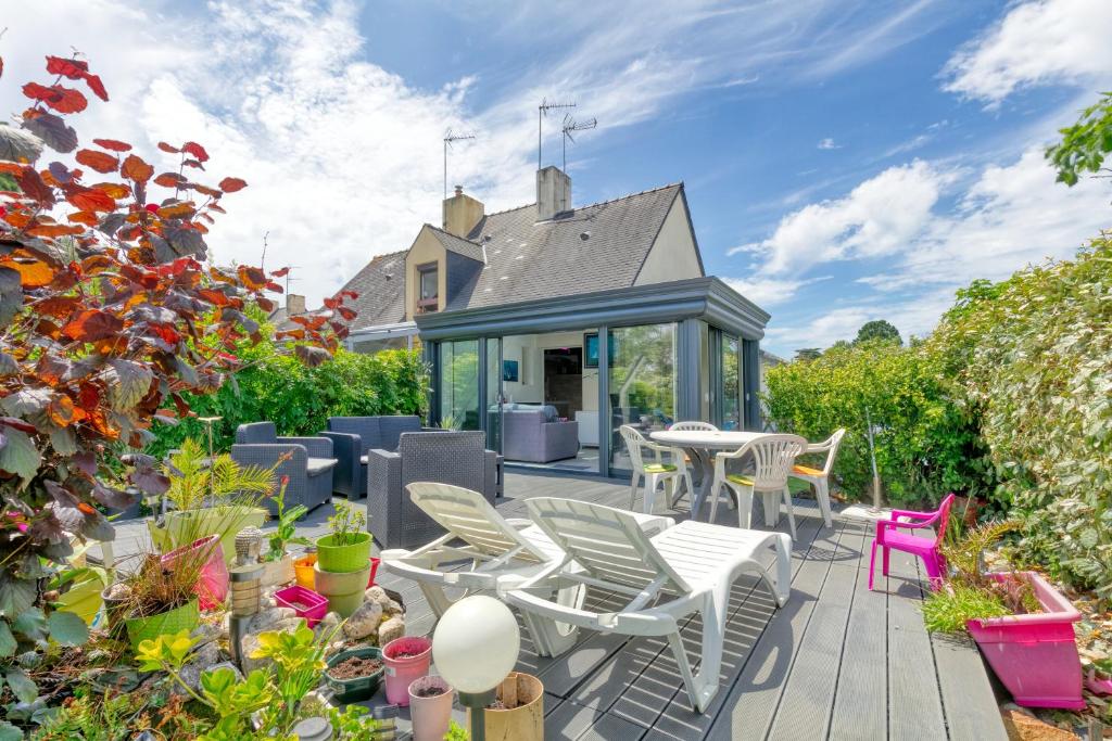 バツ・シュル・メールにあるMaison Batz-sur-mer piscineのパティオ(椅子、テーブル、植物付)