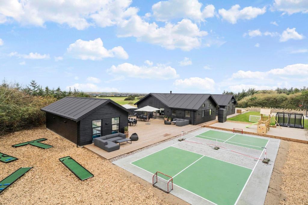 an exterior view of a house with a tennis court at Exclusive Pool And Activity House For 30 People -1002 in Ringkøbing