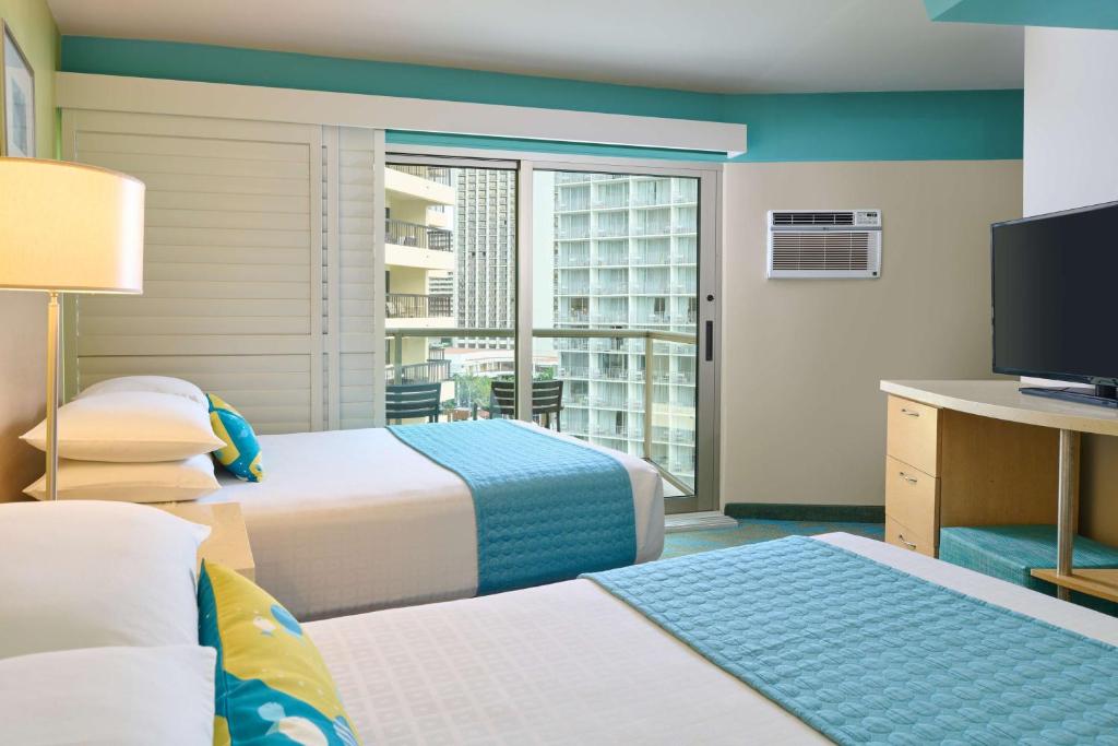 Postel nebo postele na pokoji v ubytování Aston Waikiki Circle Hotel