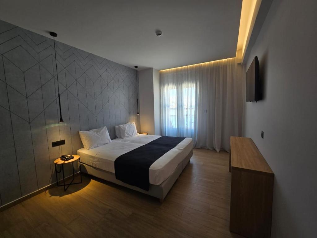 a bedroom with a large bed and a window at Nireus Hotel in Symi