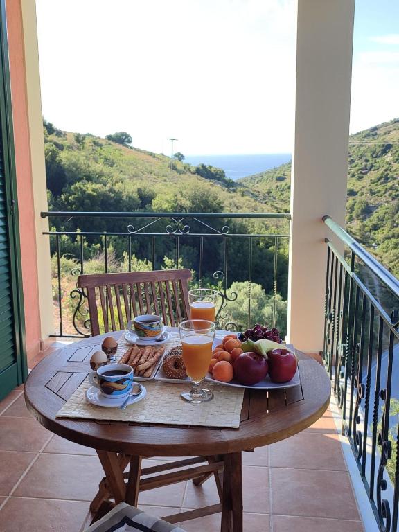 a table with a tray of fruit on a balcony at Myrtos Cottages Kefalonia in Divarata
