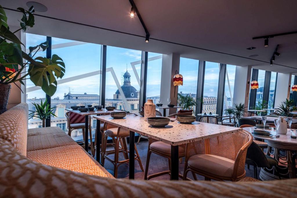 a restaurant with tables and chairs and a view of the city at Doubletree By Hilton Nice Centre Iconic in Nice