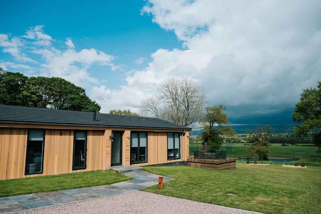 a house with a large yard next to a field at Nash - Bowland Retreat Lodges Clitheroe, Ribble Valley, Lancashire in Clitheroe