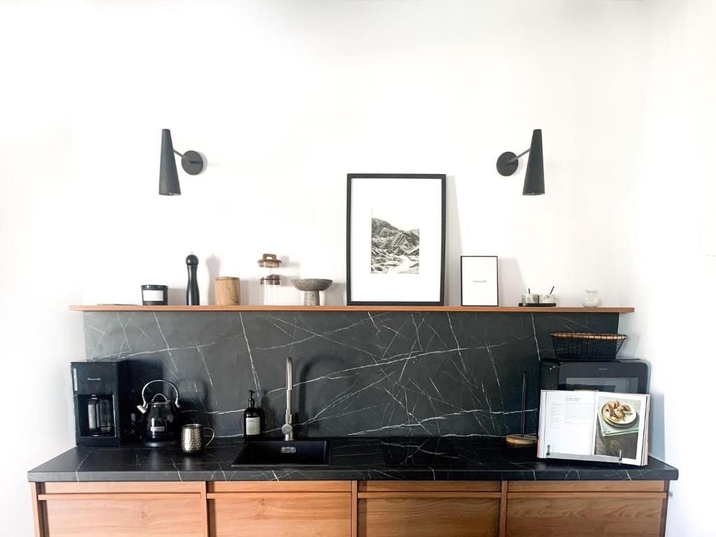 - une cuisine avec un plan de travail noir et un évier dans l'établissement Designer Wohnung nur 450 m vom Strand entfernt!, à Darłowo