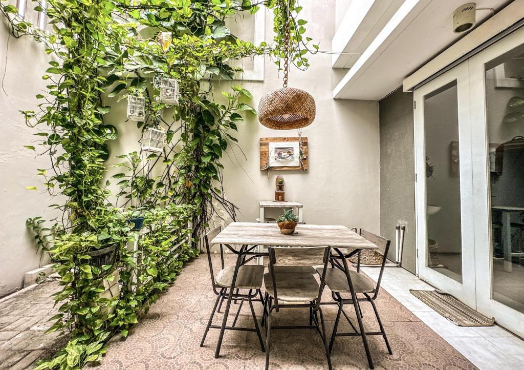 a table and chairs on a patio with plants at Royal Residence 3BR Exclusive Town House in West Surabaya by Le Ciel Hospitality in Surabaya