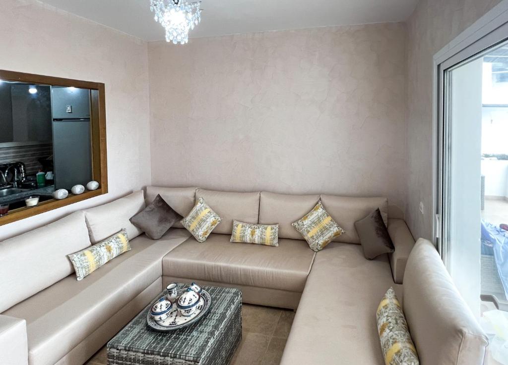 a living room with a couch with pillows at Appartement familial avec balcon et piscine in Martil