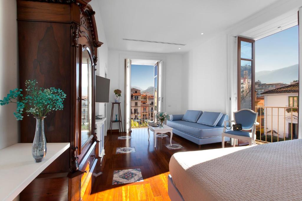 1 dormitorio con 1 cama y sala de estar con sofá en La Casa dell'Orologio - MAIN SQUARE, en Sorrento