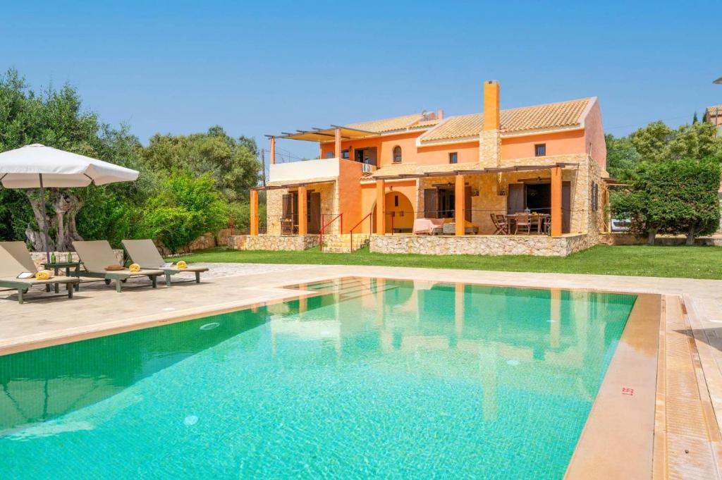 a villa with a swimming pool in front of a house at Villa Nostos by Villa Plus in Svoronata
