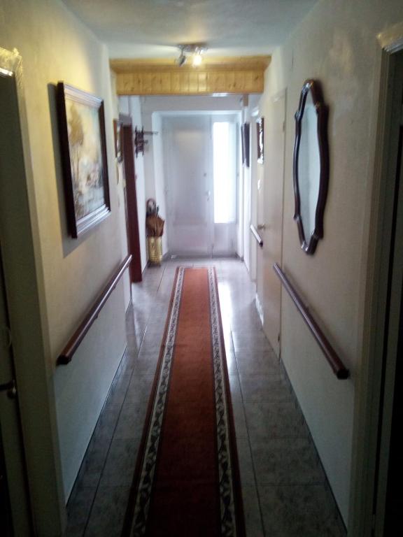 a hallway with a red rug on the floor at Camino Bed and Breakfast Corme in Corme-Puerto