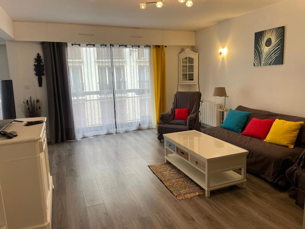 un salon avec un canapé et une table basse dans l'établissement Proche de la Campagne à Paris, à Paris