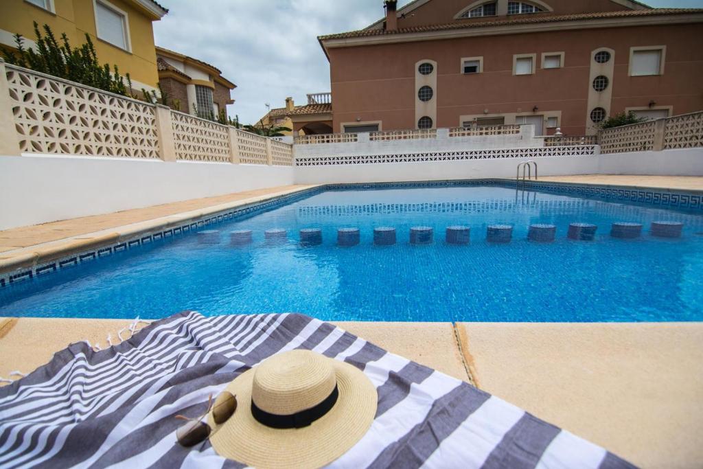einen Hut auf einer Decke neben einem Pool in der Unterkunft Villa Albufera Beach Retreat in Sueca