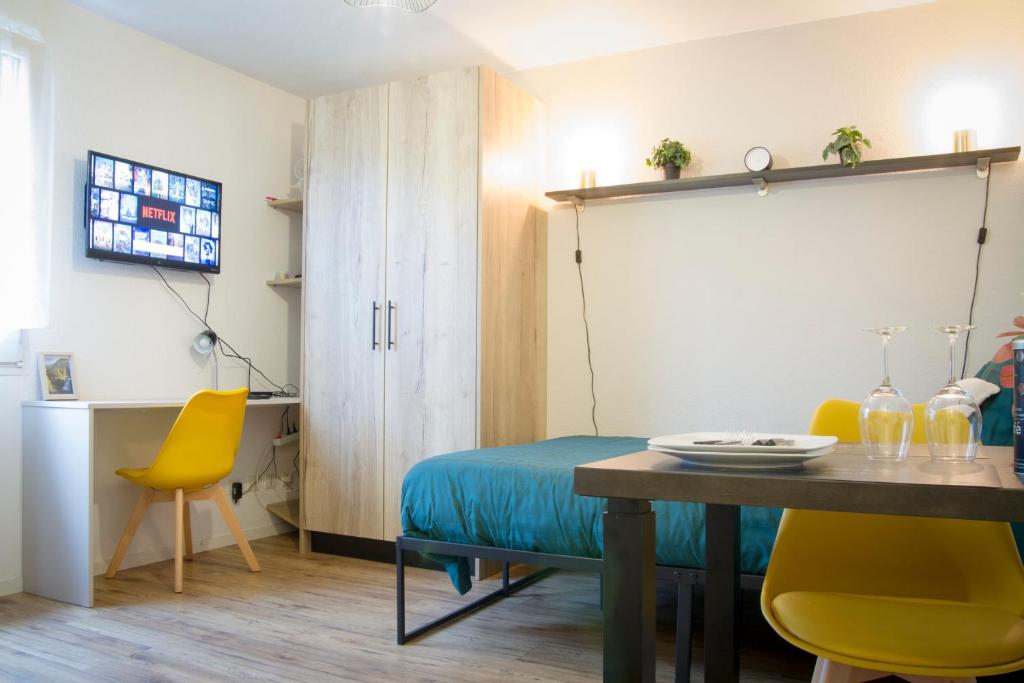 un salon avec une table et des chaises jaunes dans l'établissement Le Colibri - Parking Wifi, à Besançon