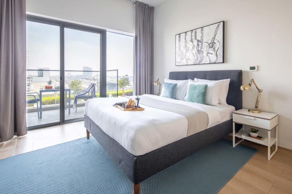 a bedroom with a large bed and a large window at Frank Porter - Azizi Aura in Dubai