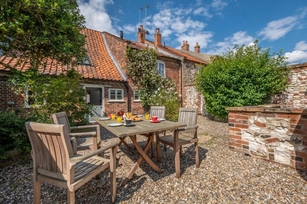 a table and chairs in the garden of a cottage at Skeet Cottage in Burnham Market